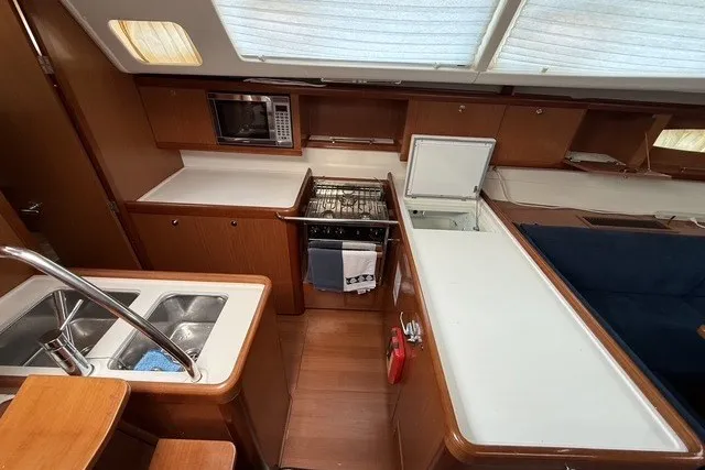 Slide: The Image of Interior of 2008 Beneteau Oceanis 46 yacht kitchen with sink, stove, and microwave. - 32