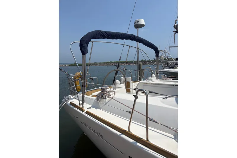 Slide: The Image of 2008 Beneteau Oceanis 46 sailboat docked, featuring a sleek deck and covered helm. - 13