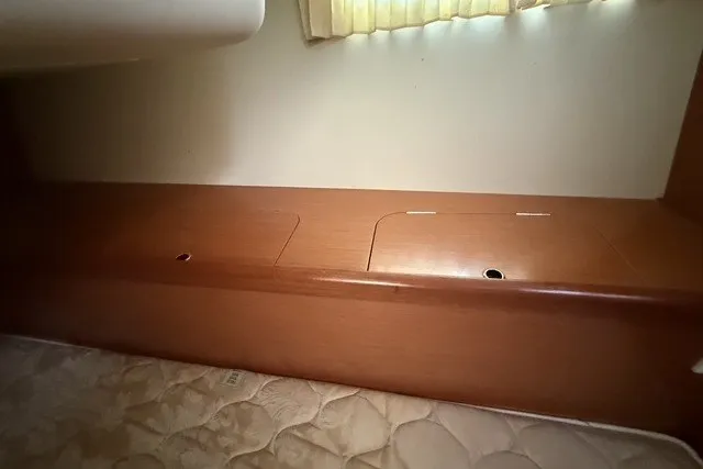 Slide: The Image of Interior view of 2008 Beneteau Oceanis 46, featuring wooden storage compartments and a mattress. - 63