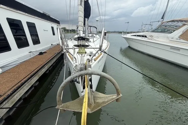 Slide: The Image of Beneteau Oceanis 46 sailboat, 2008 model, docked between two boats on a cloudy day. - 2