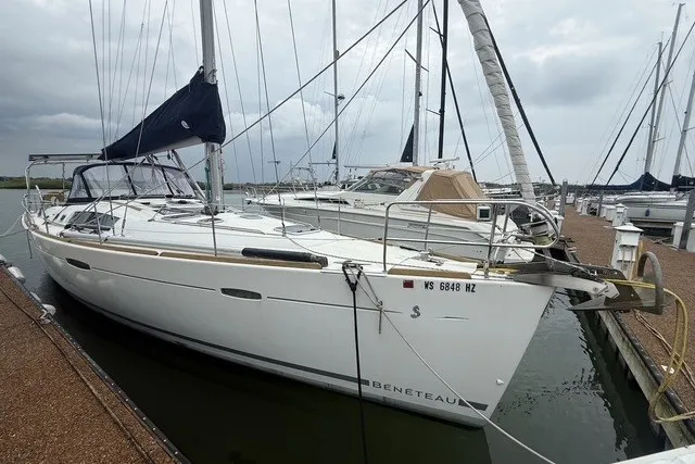 Slide: The Image of 2008 Beneteau Oceanis 46 sailboat docked at marina under cloudy sky. - 0