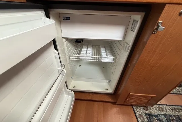Slide: The Image of Open refrigerator inside 2008 Beneteau Oceanis 46 yacht, showing interior shelves and ice trays. - 36