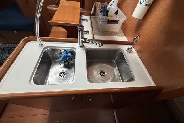 Slide: The Image of 2008 Beneteau Oceanis 46 kitchen sink area with dual basins and wooden accents. - 34