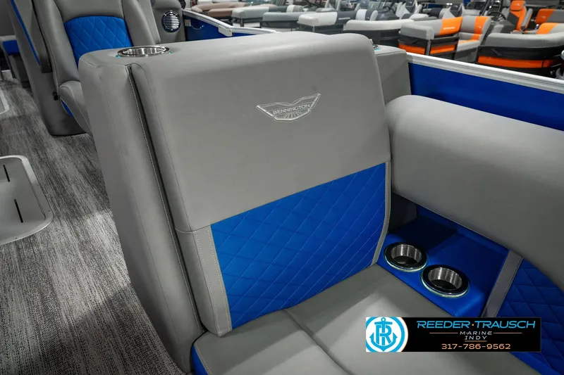 Slide: The Image of 2025 Bennington L 25 Quad Bench Bowrider interior with blue and gray seating, cup holders. - 28