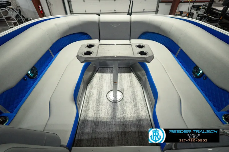 Slide: The Image of 2025 Bennington L 25 Quad Bench Bowrider interior with gray seating and blue accents. - 26
