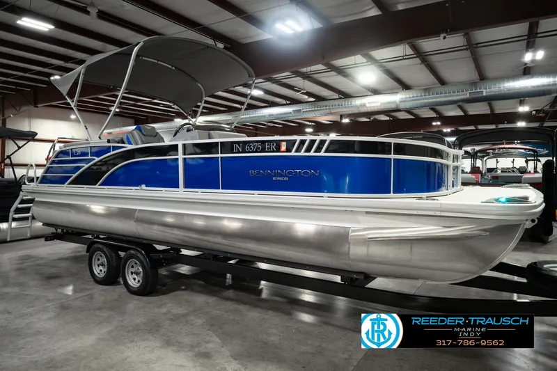 Slide: The Image of 2025 Bennington L 25 Quad Bench Bowrider pontoon boat in showroom on trailer. - 5