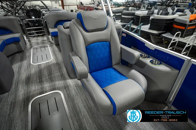 Slide: The Image of 2025 Bennington L 25 Quad Bench Bowrider interior with blue and gray seating. - 32