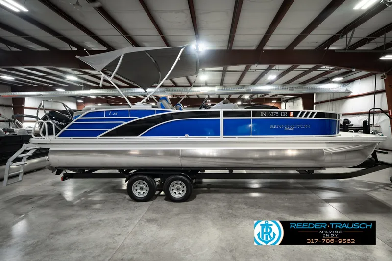 Slide: The Image of 2025 Bennington L 25 Quad Bench Bowrider pontoon boat in showroom, side view. - 6