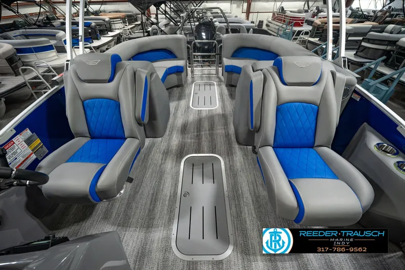 Slide: The Image of 2025 Bennington L 25 Quad Bench Bowrider with blue and gray seating in showroom. - 20