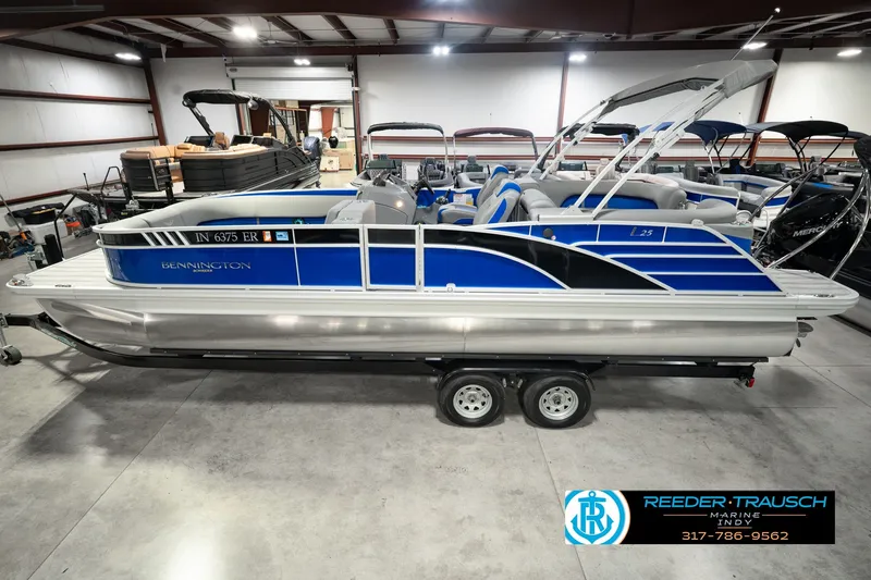 The Image of 2025 Bennington L 25 Quad Bench Bowrider in showroom, blue and silver design. - 0