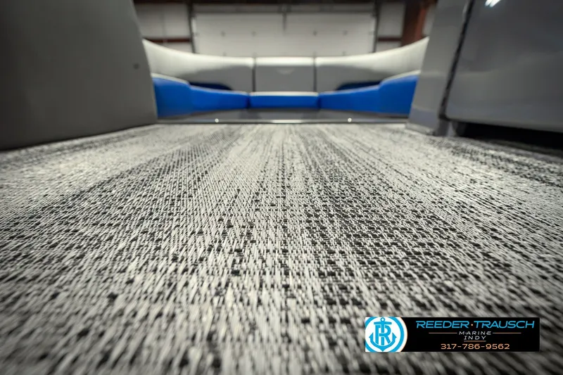 Slide: The Image of 2025 Bennington L 25 Quad Bench Bowrider interior with textured flooring and seating. - 50
