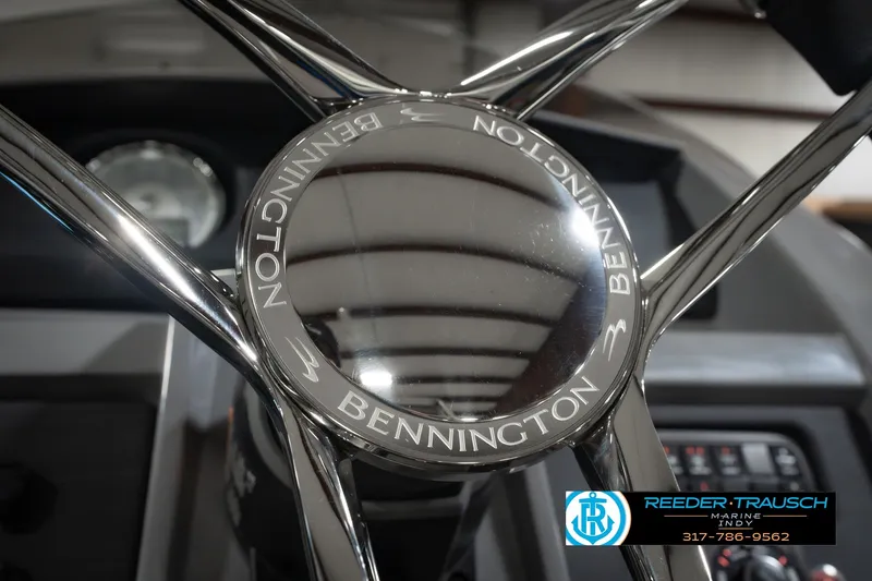 Slide: The Image of Steering wheel of 2025 Bennington L 25 Quad Bench Bowrider, featuring sleek chrome design. - 37
