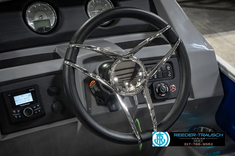 Slide: The Image of Steering wheel of 2025 Bennington L 25 Quad Bench Bowrider with dashboard controls. - 36