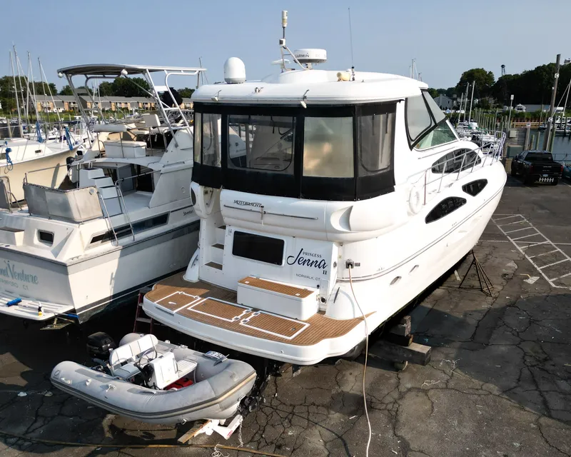 Slide: The Image of A 2007 Cruisers Yachts 455 Motor Yacht is on a dry dock next to an inflatable boat. - 2