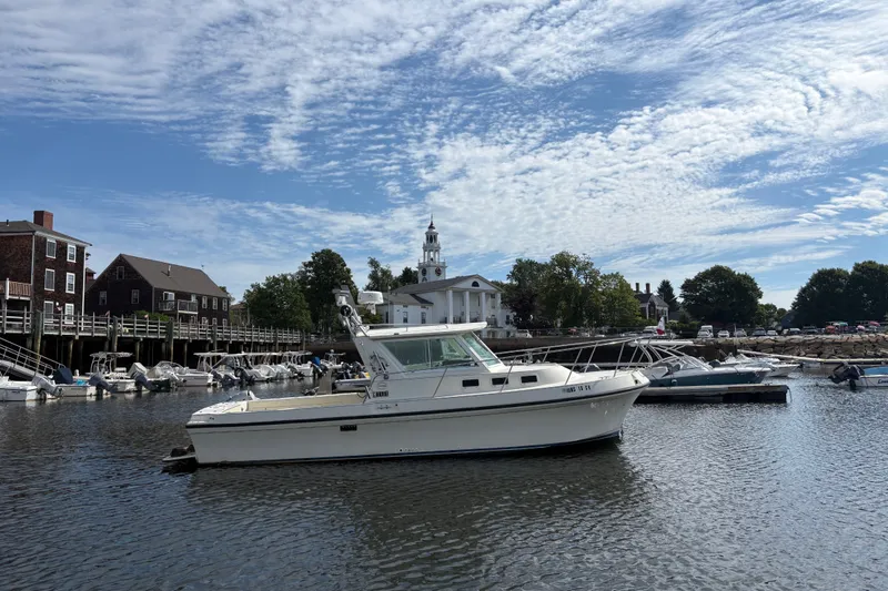 The Image of 1998 Albin 28 Tournament Express boat docked in a scenic harbor with historic buildings. - 0