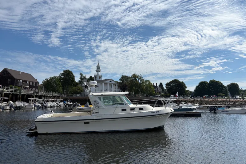 Slide: The Image of 1998 Albin 28 Tournament Express boat docked in a scenic harbor under a blue sky. - 1