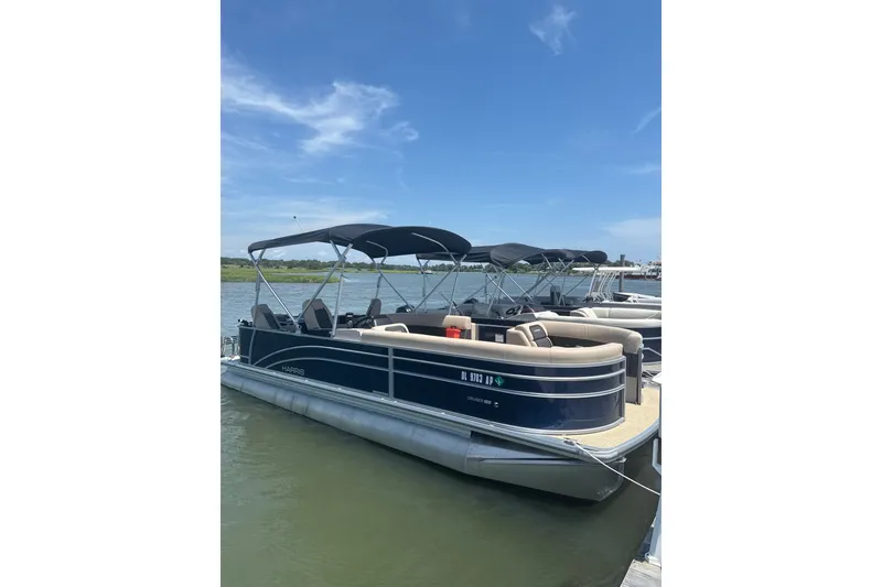 The Image of 2025 Harris Cruiser 230 pontoon boat docked on a sunny day. - 1