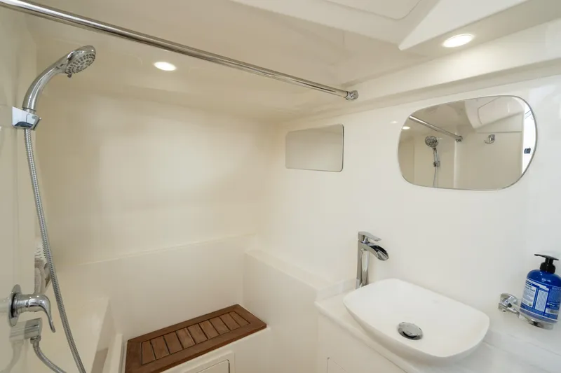 Slide: The Image of 2024 World Cat 400 DC-X boat bathroom with shower, sink, and mirror. - 24