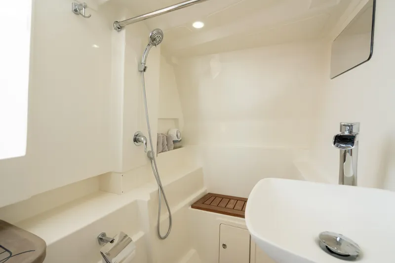 Slide: The Image of 2024 World Cat 400 DC-X boat bathroom with shower, sink, and modern fixtures. - 25