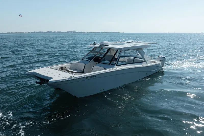 Slide: The Image of 2024 World Cat 400 DC-X boat cruising on open water under clear skies. - 5