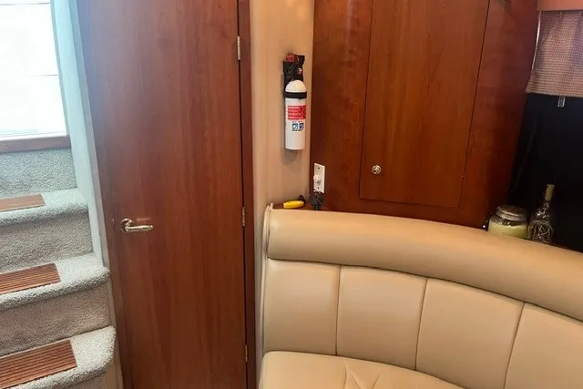 Slide: The Image of Interior of 2001 Cruisers Yachts 4270 Express with beige seating and wooden cabinetry. - 21