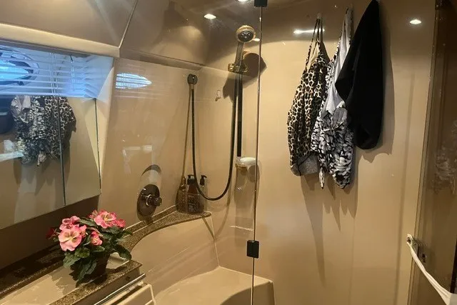 Slide: The Image of Luxurious bathroom in 2001 Cruisers Yachts 4270 Express with floral decor and hanging clothes. - 28