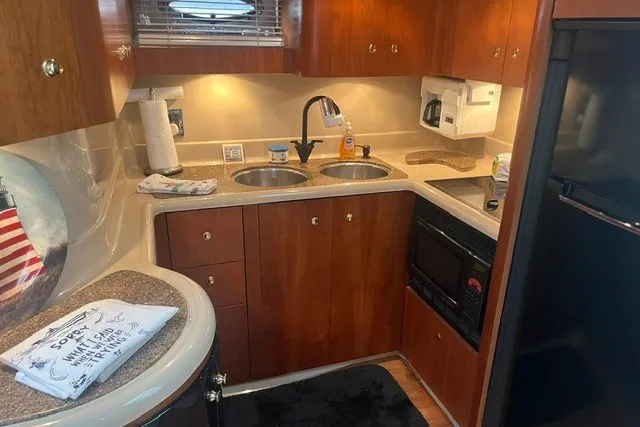 Slide: The Image of 2001 Cruisers Yachts 4270 Express kitchen with wood cabinets, dual sinks, and modern appliances. - 23