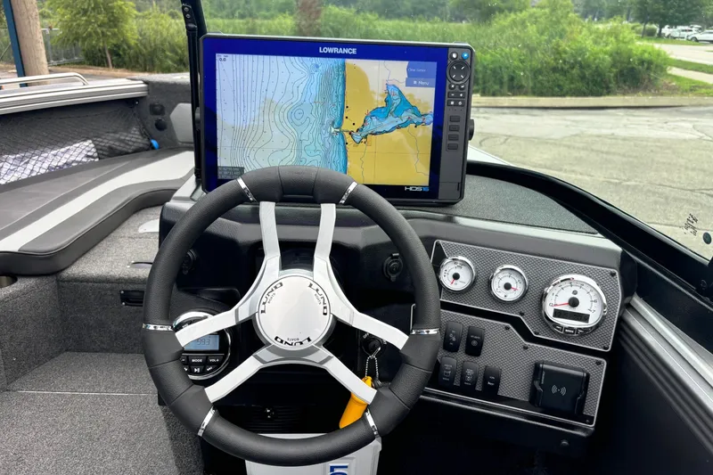 Slide: The Image of 2025 Lund 2275 Baron boat dashboard with steering wheel and navigation display. - 21