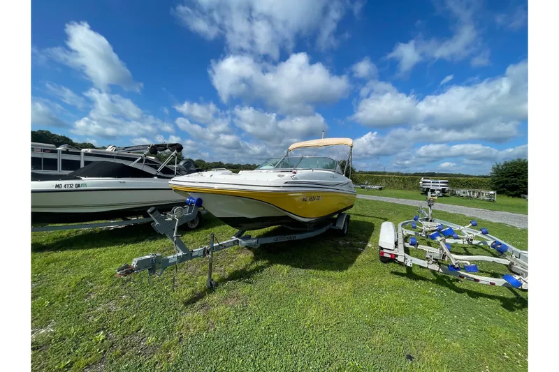 The Image of 2013 Hurricane SunDeck 187 OB boat on trailer under a blue sky. - 0