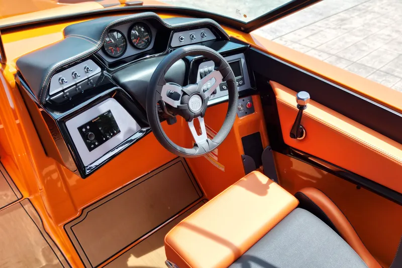 Slide: The Image of 2022 MasterCraft NXT24 boat cockpit with orange interior and modern steering controls. - 10