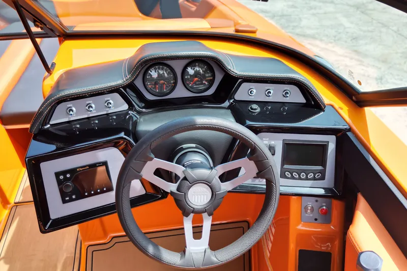 Slide: The Image of 2022 MasterCraft NXT24 boat dashboard with steering wheel and control panels. - 11