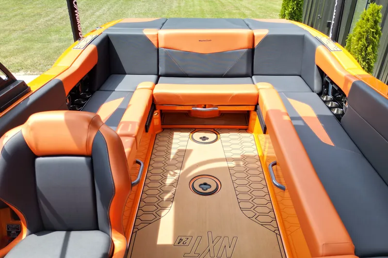 Slide: The Image of 2022 MasterCraft NXT24 boat interior with orange and gray seating, showcasing luxury design. - 5