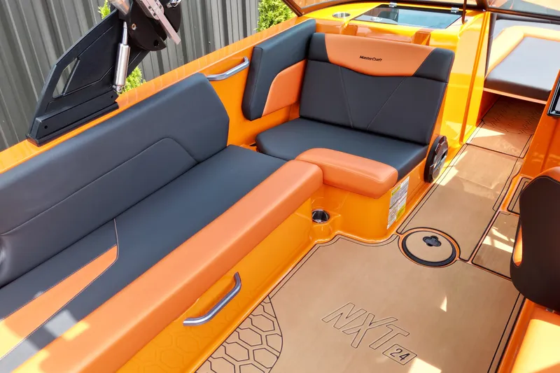 Slide: The Image of 2022 MasterCraft NXT24 boat interior with orange and gray seating, showcasing modern design. - 9