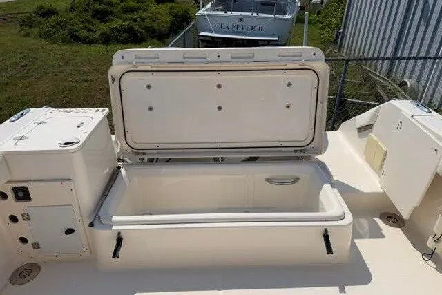 Slide: The Image of 2010 Pursuit OS 285 Offshore boat with open storage compartment on deck. - 29