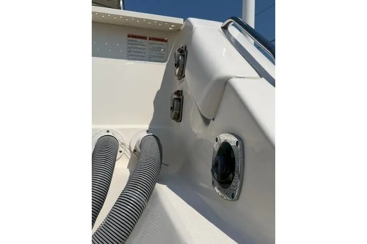 Slide: The Image of 2010 Pursuit OS 285 Offshore boat interior, featuring hoses and fittings. - 15