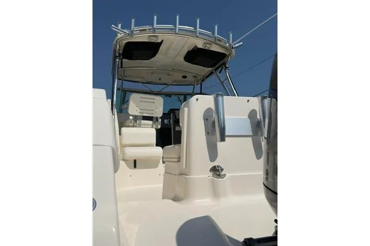 Slide: The Image of 2010 Pursuit OS 285 Offshore boat interior with seating and canopy under clear sky. - 17