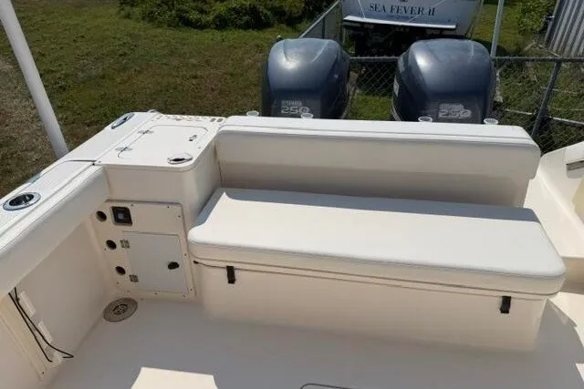 Slide: The Image of 2010 Pursuit OS 285 Offshore boat with dual engines and cushioned seating area. - 24