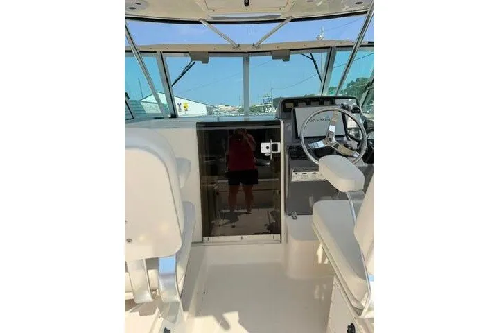 Slide: The Image of 2010 Pursuit OS 285 Offshore boat interior with helm and seating area. - 38