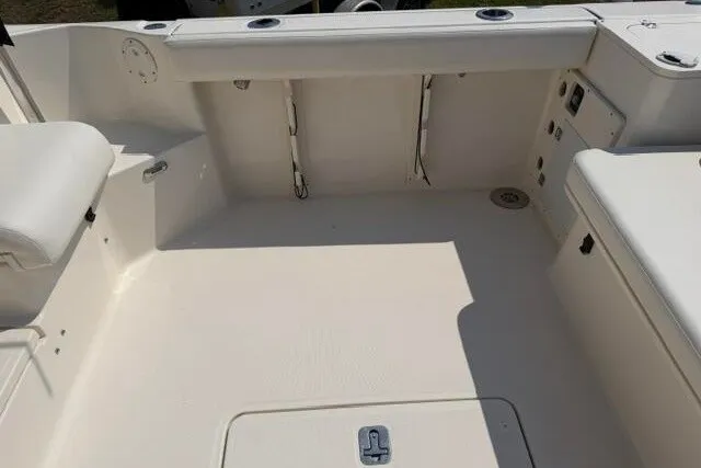 Slide: The Image of 2010 Pursuit OS 285 Offshore boat deck, featuring spacious seating and storage compartments. - 22