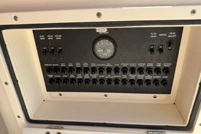 Slide: The Image of Control panel of a 2010 Pursuit OS 285 Offshore boat, featuring various switches and a battery gauge. - 43