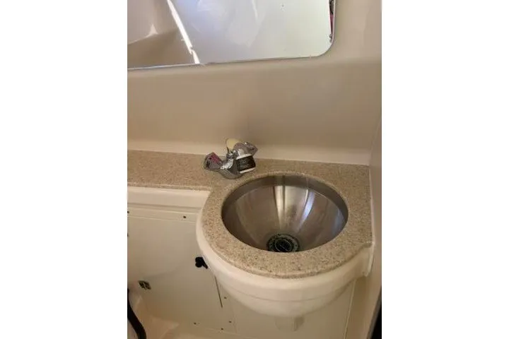 Slide: The Image of 2010 Pursuit OS 285 Offshore boat interior sink with countertop and faucet. - 69