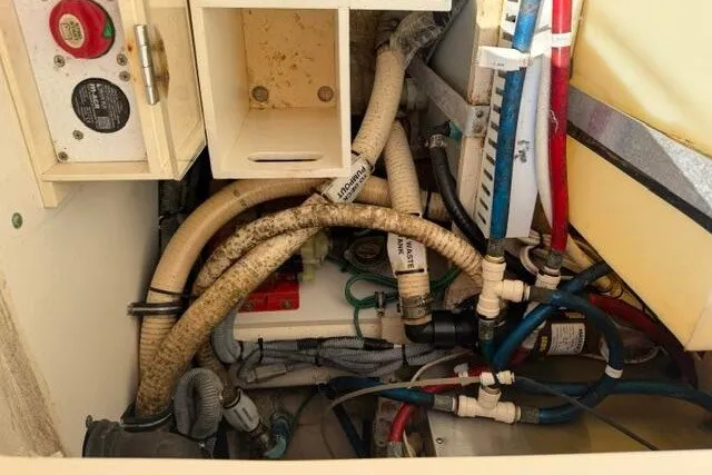 Slide: The Image of Engine compartment of a 2010 Pursuit OS 285 Offshore boat, showing hoses and wiring. - 58