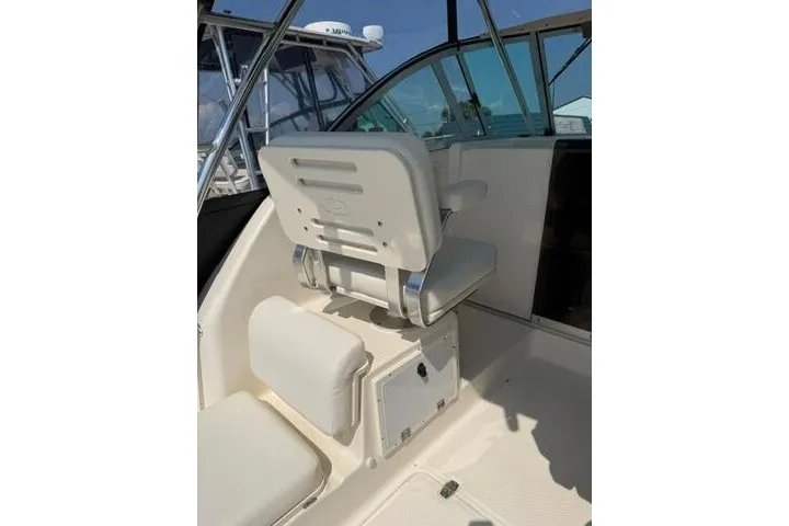 Slide: The Image of 2010 Pursuit OS 285 Offshore boat interior with white seating and helm station. - 36