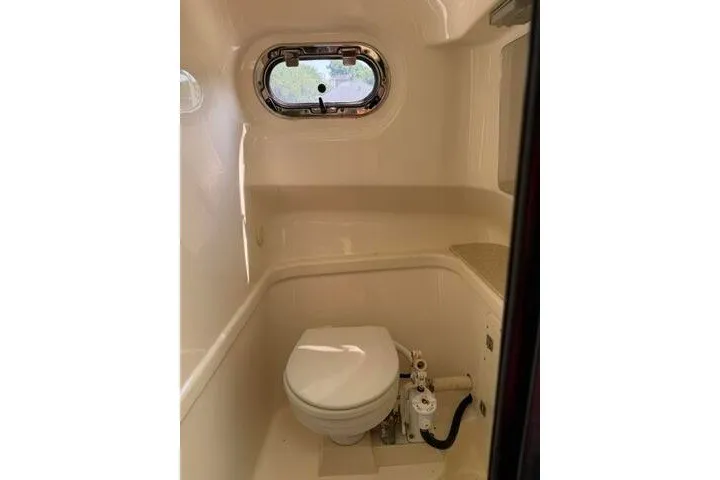 Slide: The Image of 2010 Pursuit OS 285 Offshore boat bathroom with porthole window and compact toilet. - 70