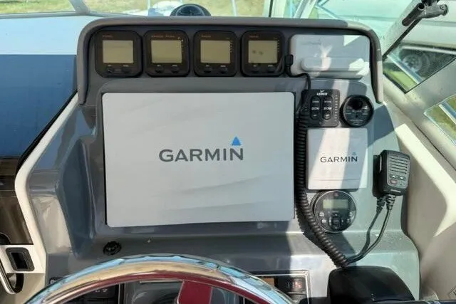 Slide: The Image of Dashboard of 2010 Pursuit OS 285 Offshore with Garmin navigation system and controls. - 45