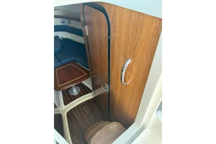 Slide: The Image of 2010 Pursuit OS 285 Offshore cabin interior with wooden door and seating area. - 52