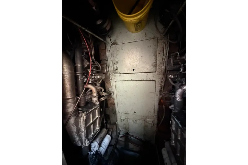 Slide: The Image of Engine room of 1989 Egg Harbor 41 Convertible boat, featuring mechanical components and piping. - 48