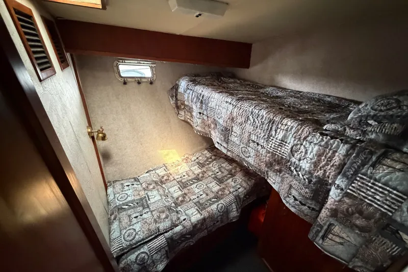 Slide: The Image of Cozy bunk beds in 1989 Egg Harbor 41 Convertible cabin, featuring patterned bedding and a small window. - 22