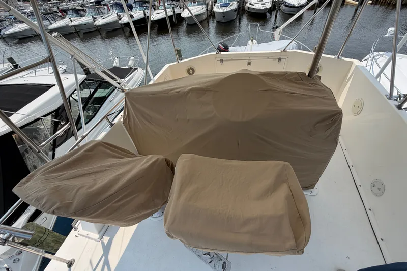 Slide: The Image of 1989 Egg Harbor 41 Convertible boat with covered seating at a marina. - 39