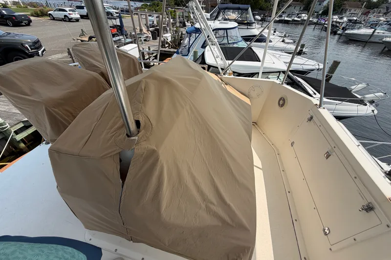 Slide: The Image of 1989 Egg Harbor 41 Convertible yacht with covered equipment on deck, docked at a marina. - 38
